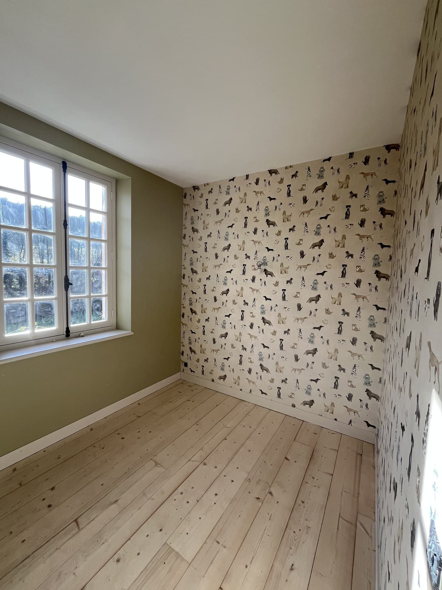 Comble aux murs à motif d’oiseaux, soubassement vert et parquet pin clair