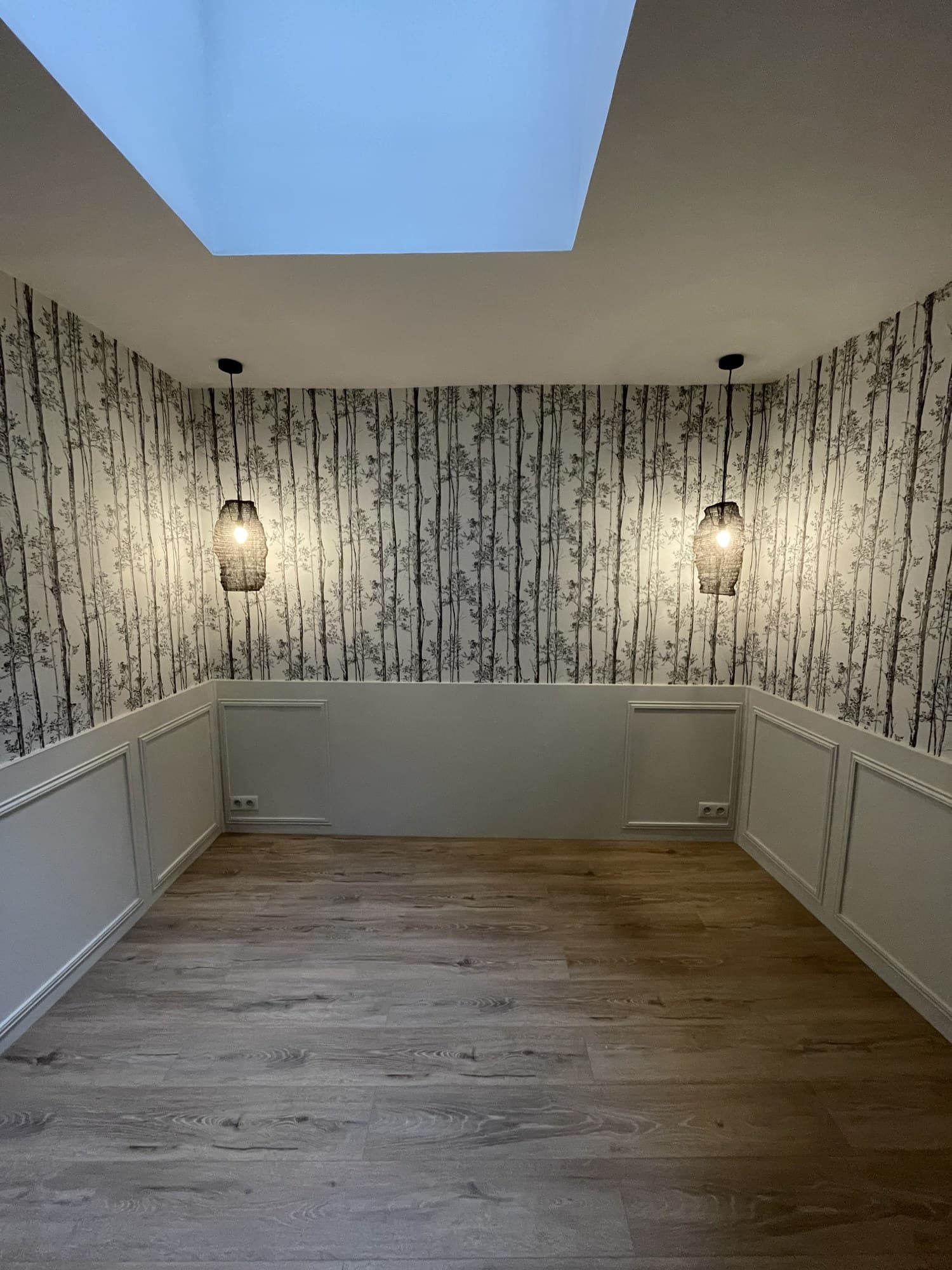 La même chambre vue de l’autre angle, éclairée par une fenêtre de toit